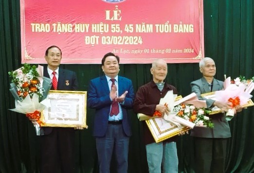 Đồng chí Nguyễn Văn Hồng, Trưởng Ban tổ chức Huyện uỷ trao Huy hiệu Đảng cho các đảng viên