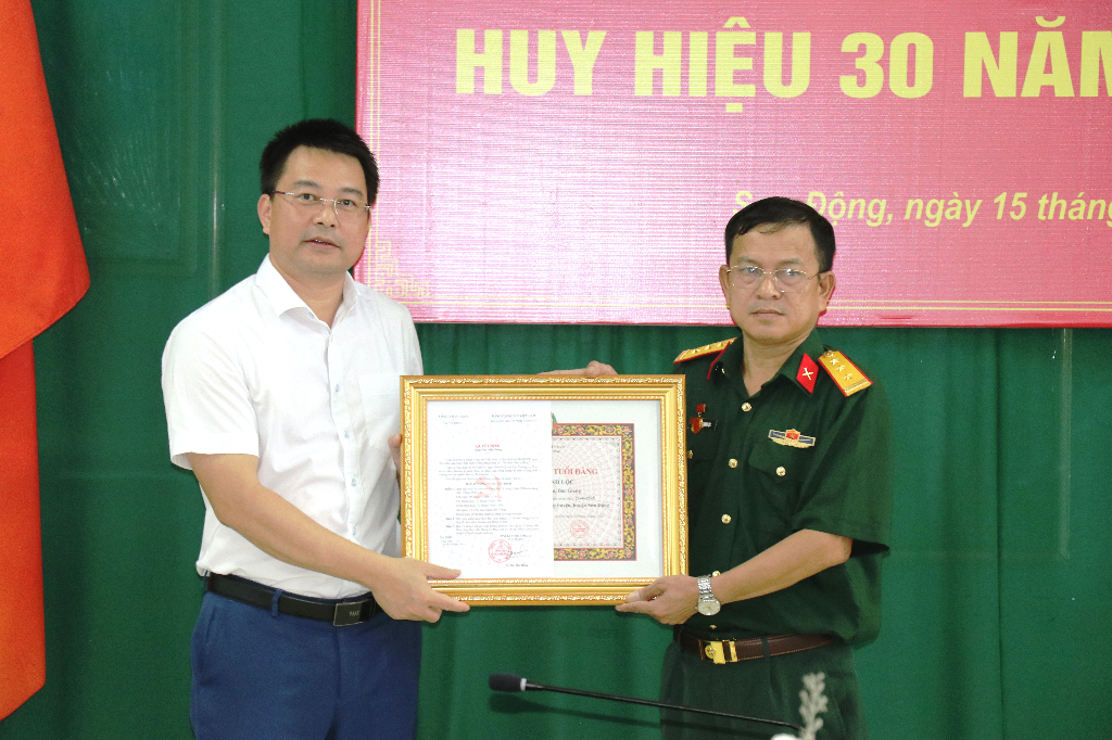 Bí thư Huyện uỷ Ngụy Văn Tuyên trao tặng Huy hiệu 30 năm tuổi Đảng cho Thượng tá Thăng Minh Lộc