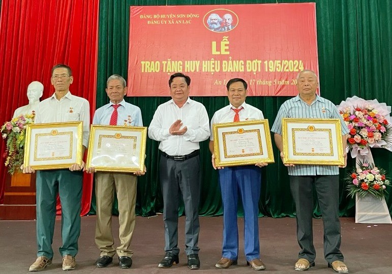 Trưởng Ban Tổ chức Huyện ủy Nguyễn Văn Hồng trao Huy hiệu Đảng cho các đảng viên